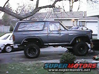 Lifted 1980s Ford Bronco parked next to a white sedan