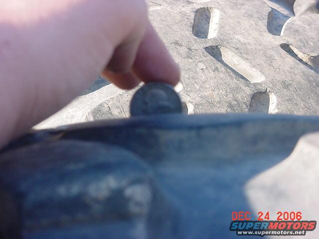 hand holding coin on tire tread
