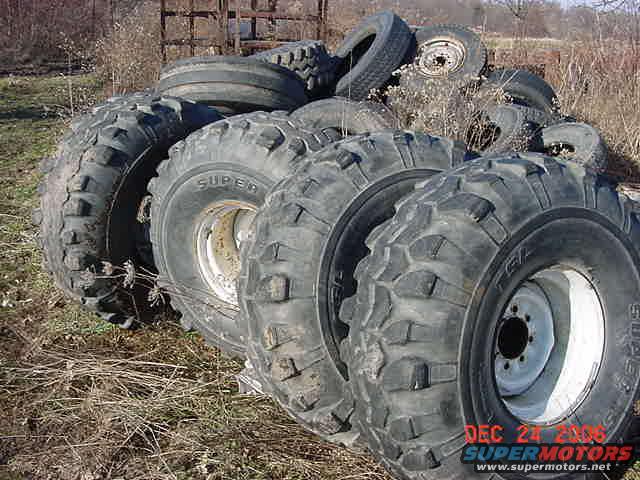 Pile of off-road tires with visible text 'SUPERMOTORS'