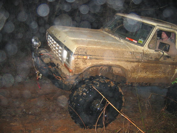 Mud-covered 1979 Ford F-Series pickup truck, front 3/4 view, off-roading