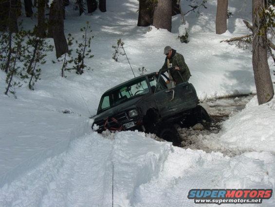 off-road vehicle stuck in deep snow with a person getting out