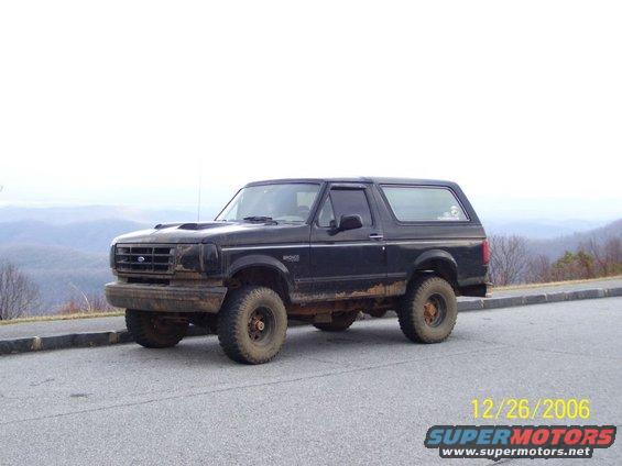 1993 Ford Bronco parked on a roadside with mountains in the background
