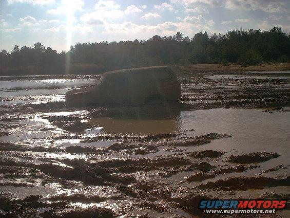 Mud-covered SUV stuck in a muddy field