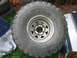 1986 Ford Bronco - A close-up of a large off-road tire and wheel assembly is shown, with other tires in the background.