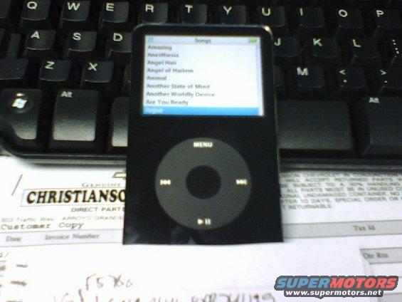 Black iPod Classic on a keyboard and paperwork