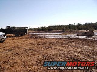 Trucks stuck in mud under a clear sky