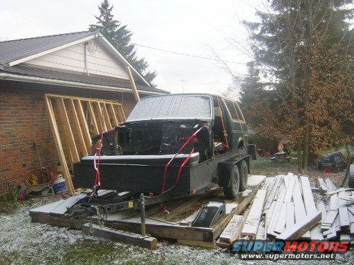 SUV body on a trailer, front end removed, strapped down in snowy weather