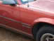 1995 Ford Bronco - Close-up of a red car's side panel showing the 'CAMARO' emblem.