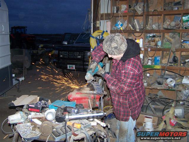 Black Ford Bronco in a garage, front view, with sparks flying from grinding