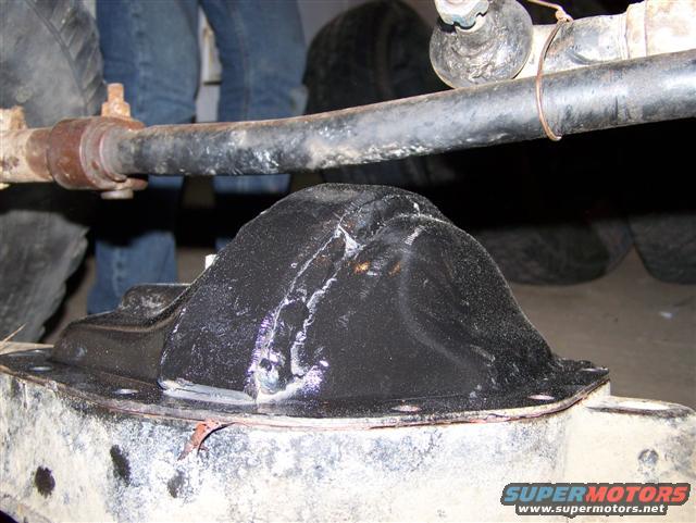 Differential housing with black cover and metal tie-wrap, close-up