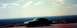1997 Ford Crown Victoria - A black sedan is parked on the side of a road with a scenic view of water and trees.