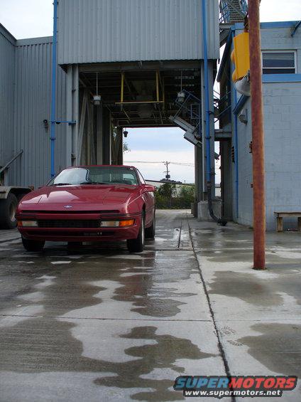 1991 Ford Probe front view, parked on wet concrete near industrial building