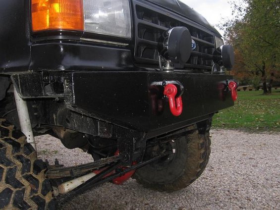 Front of a 1991 Ford Bronco with a custom black bumper and red tow hooks