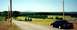 1997 Ford Crown Victoria - A black 1997 Ford Crown Victoria is seen from the rear as it travels down a country road with rolling hills in the background.