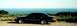 1997 Ford Crown Victoria - Side view of a black 1997 Ford Crown Victoria parked with a scenic ocean backdrop.