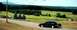 1997 Ford Crown Victoria - A black 1997 Ford Crown Victoria is seen from the side as it drives along a paved road in a rural setting.