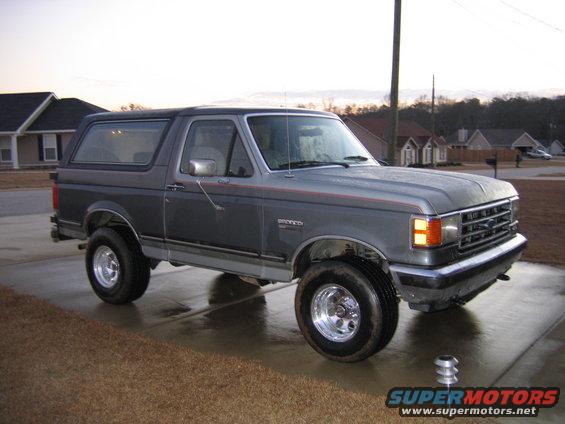 1989 Ford Bronco parked on a wet driveway