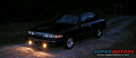 1997 Ford Crown Victoria parked on gravel at night, headlights on