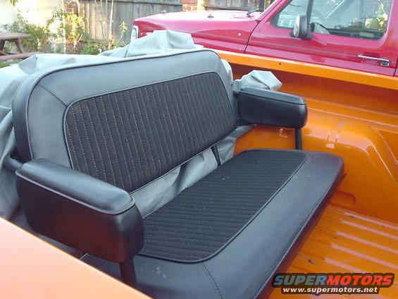 Rear bench seat with black upholstery and orange interior