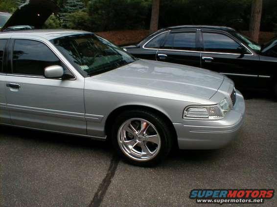 Silver sedan parked next to a black sedan. Chrome wheels on silver car