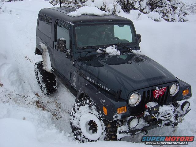 Dark green Jeep Wrangler Rubicon with winch in snow