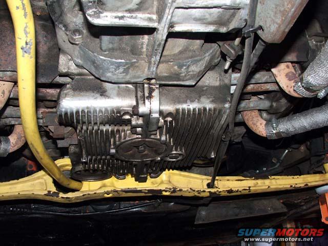 Undercarriage view of engine and exhaust system with yellow hose