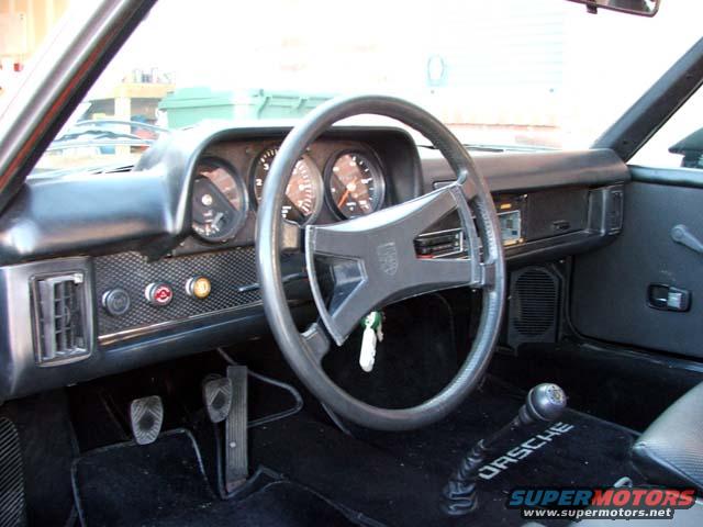 1974 Porsche 914 interior showing dashboard, steering wheel, pedals, and gear shift