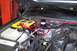 2002 Chevrolet Suburban - The engine bay shows a custom audio system installation with a yellow battery and red power cables.