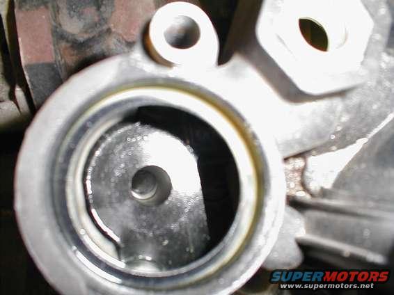 Close-up of a metallic engine component with a circular opening and visible internal mechanism