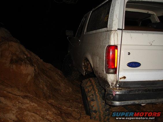 1989 Ford Bronco rear quarter view, muddy, off-roading at night