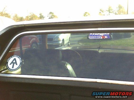 Interior view of a vehicle showing the rear window with 'Ranchero' and 'Appalachian Trail' stickers. Other vehicles are visible through the window
