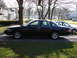 2003 Ford Crown Victoria - Side profile of a black 2003 Ford Crown Victoria sedan parked in a driveway.