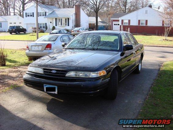 Black 2003 Ford Crown Victoria parked in driveway, silver sedan behind it