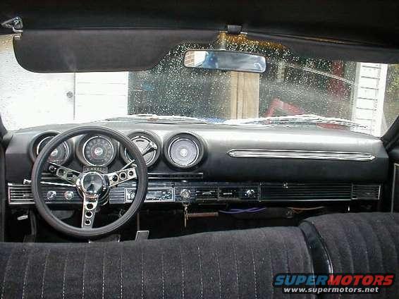 1968 Ford Torino interior dashboard with four gauges, aftermarket steering wheel, and radio