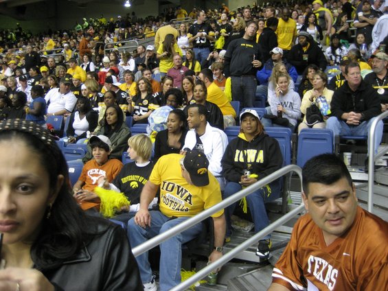 Spectators in stadium seating, many wearing black and yellow