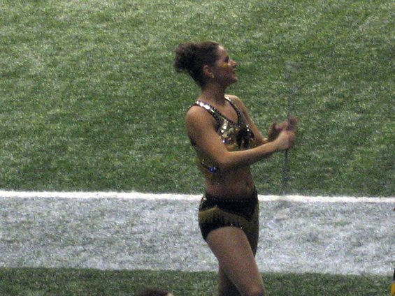 Woman in sparkly uniform on a grassy field