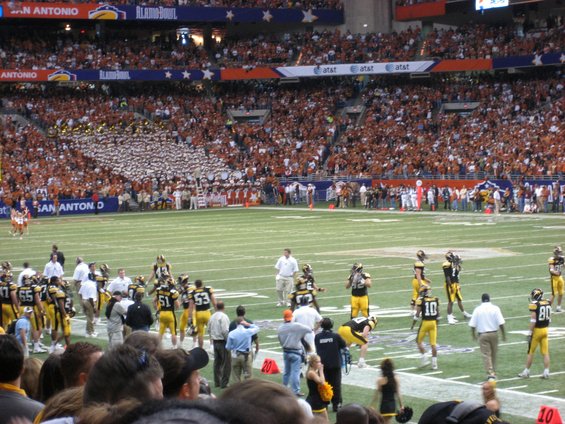 Football game in a stadium with fans and players on the field