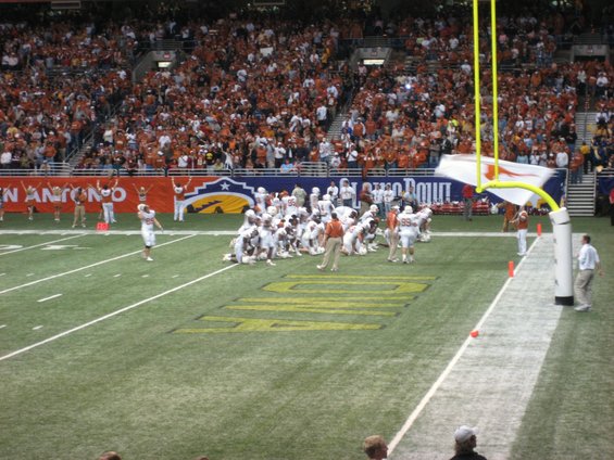 Football players on field during a game with crowd in stands