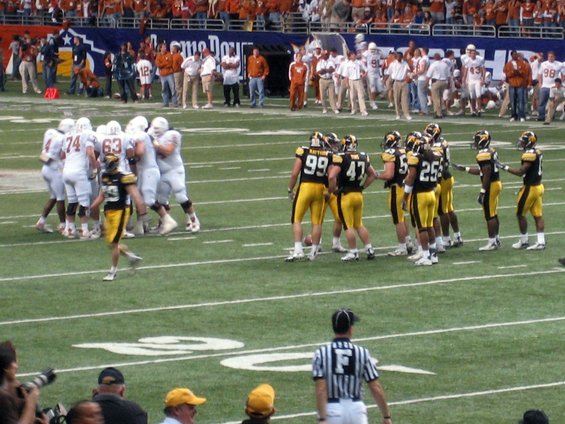 American football game with players in white and black uniforms on the field