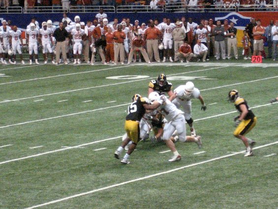 Football players in action on a green field with white yard lines