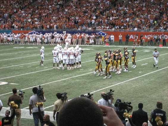 Football players on a field with spectators in the background