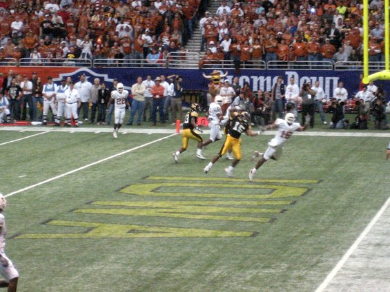 football players on field during game, crowd in stands