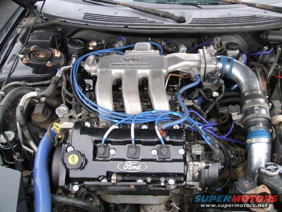 Ford V6 engine with blue spark plug wires and silver intake manifold