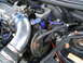 1997 Ford Probe - Close-up view of an engine bay, chrome intake piping, blue hoses, and the brake fluid reservoir.