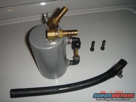Oil catch can assembly with brass fittings, black hose, and two bolts. Watermark reads JAN 1 2007 SUPERMOTORS.NET