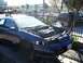 1992 Ford Taurus - A blue sedan, possibly a Ford Taurus, is parked with its hood open and missing a headlight, supported by jack stands.