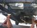 1992 Ford Taurus - The underside of a car is visible, supported by jack stands, with a focus on the exhaust and transmission components.