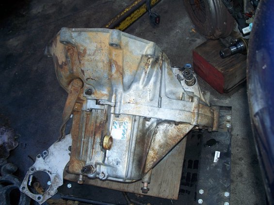 Automatic transmission with a sticker on its side, resting on a wooden surface