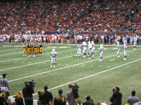 Football game in a stadium with players on the field and spectators in the stands