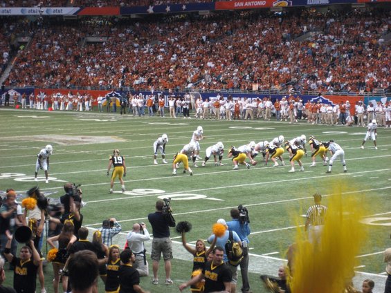 Football game with fans in stands and players on field